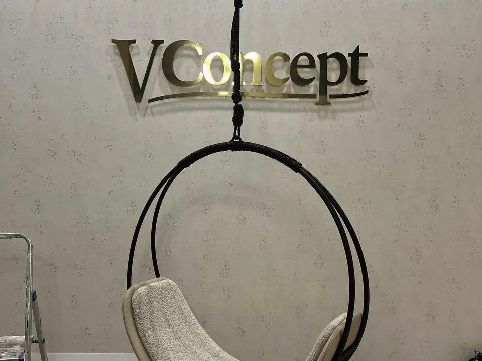 Goldene 3D-Buchstaben an der Wand über einem Hängesessel