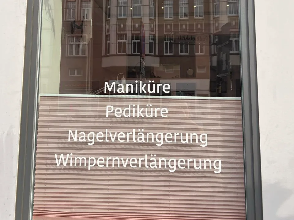 Schaufenster mit Milchglasfolie und weißer Leistungsbeschriftung