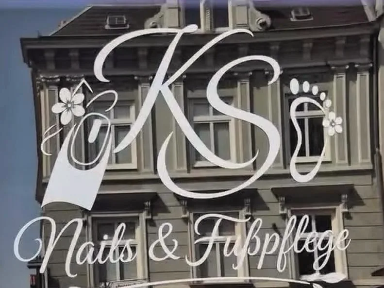 Weißer Folienschriftzug mit Logo auf dem Schaufenster eines Nagelstudios
