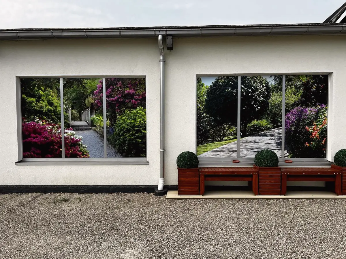 Zwei Fensterfronten mit großformatig bedruckter Folie mit Gartenmotiv