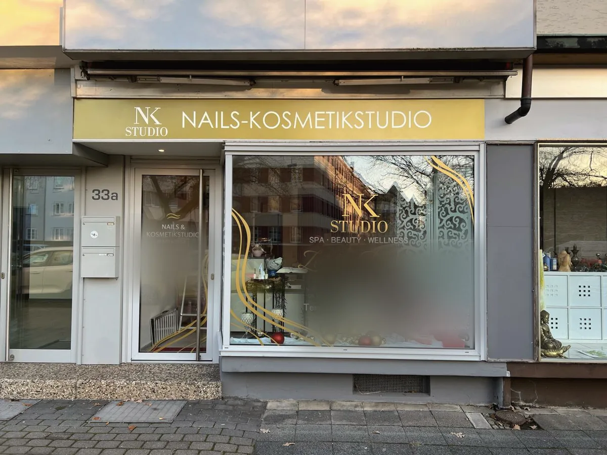 Schaufenster eines Nagel- und Kosmetikstudios mit goldener Folienbeschriftung
